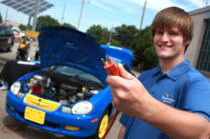 Matt Bechberger, an electronic engineering student at Sheridan College, holds up an electrical plug that can be plugged into their electric car conversion project.